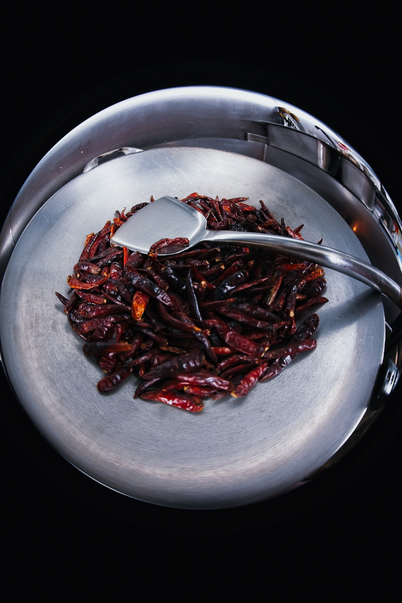 Close-up visual representing roasted chilli heat. Roasted chillies for smoky depth and bite, never pointless burn.